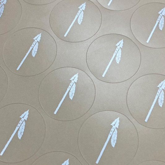 White arrow symbols on brown circular stickers