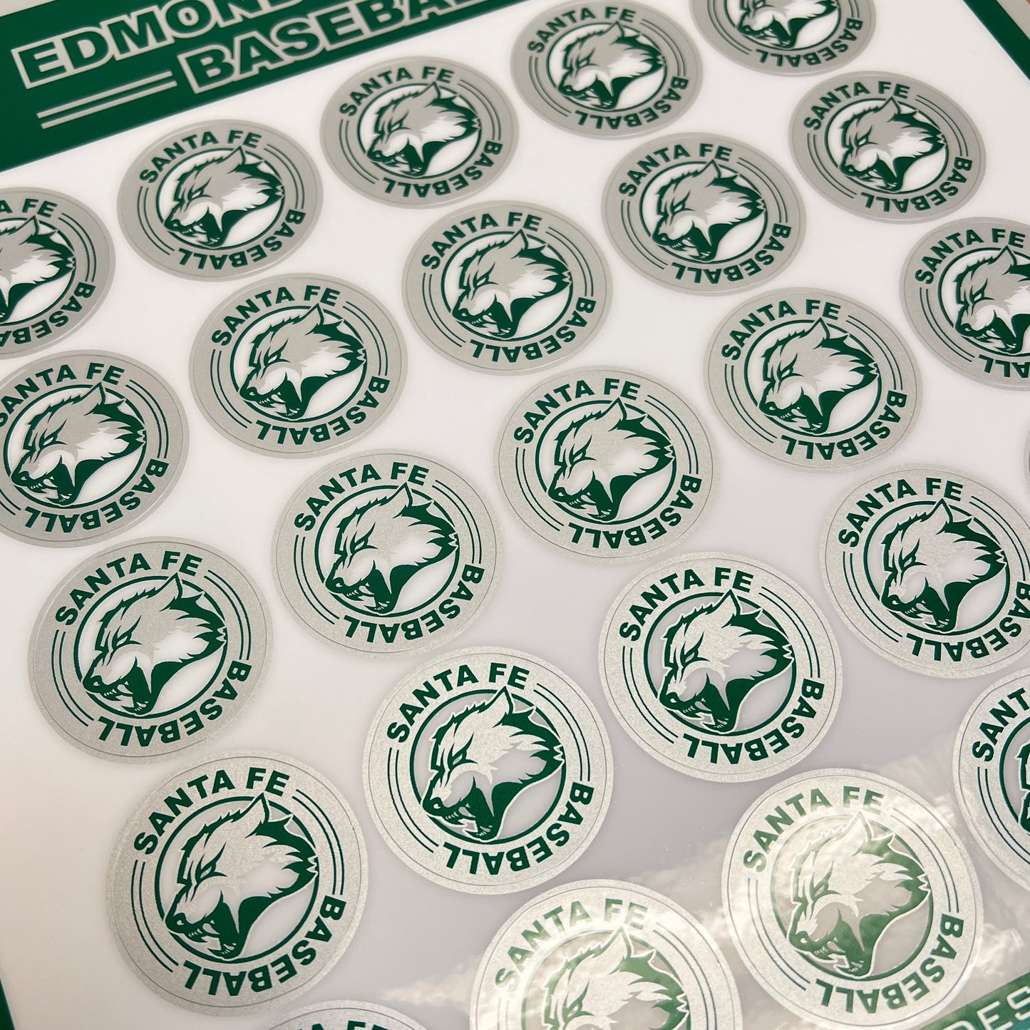 Sheet of baseball stickers with a green and white design on a cutting mat.
