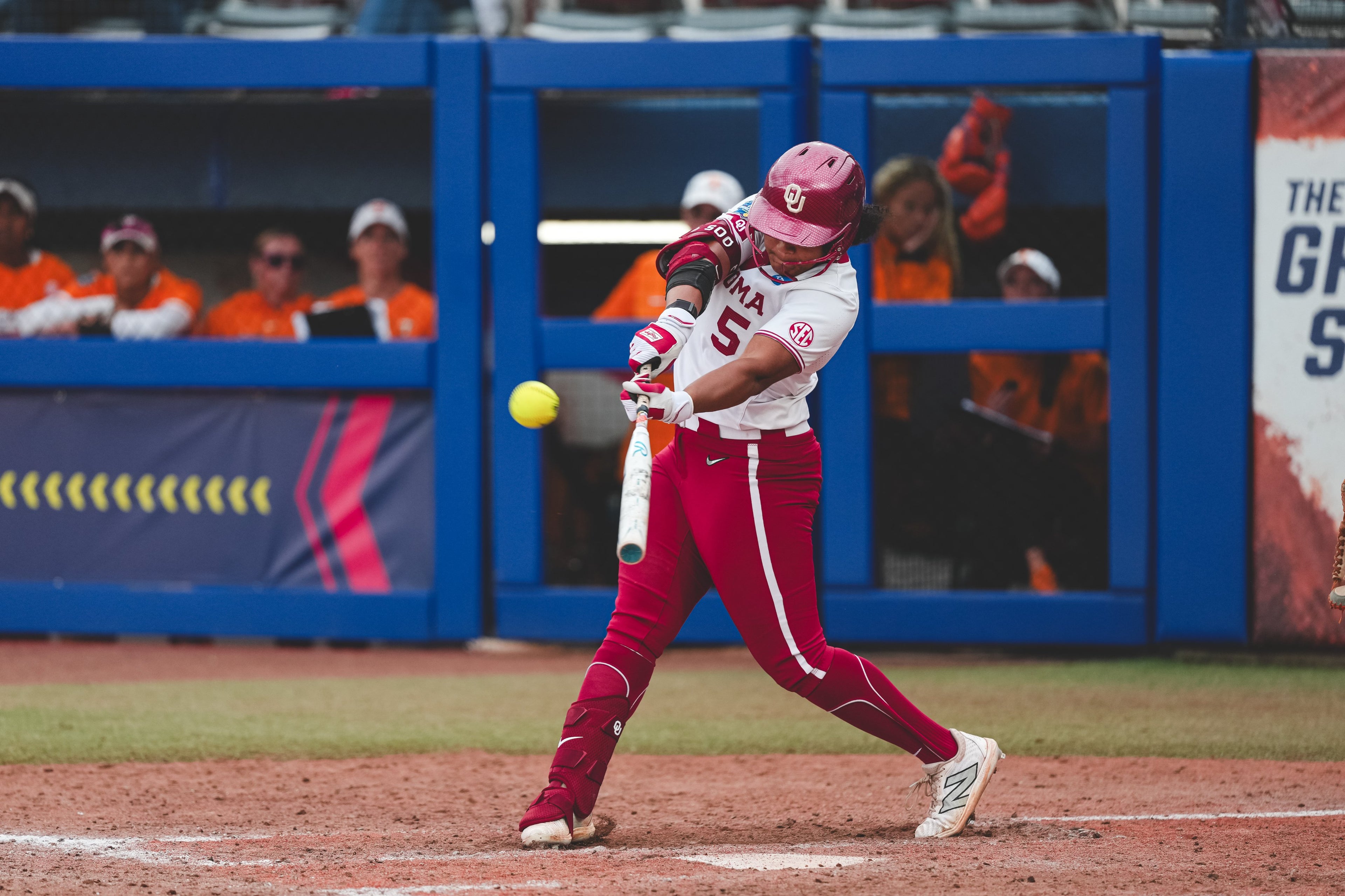 Baseball player in red and white uniform swinging a bat on a baseball field.