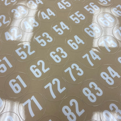 Circular stickers with white numbers on a beige background